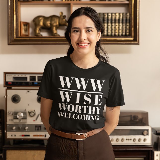 Camiseta WWW- Sábio, digno, bem-vindo (Young woman wears a black t-shirt that read "WWW: Wise, Worthy, Welcoming")
