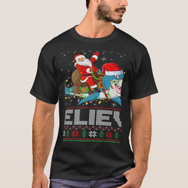 Camiseta Xmas Lights Shark Believe Ugly Santa Riding Shark  (Frente)