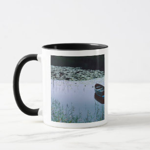 Caneca Barco a remo em pequeno lago rodeado por água