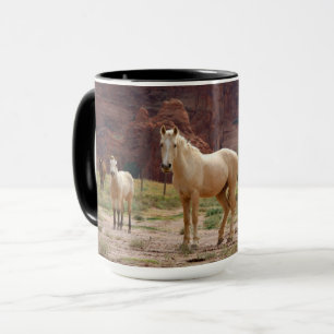 Caneca Cavalos Navajo correm livres no chão do Canyon