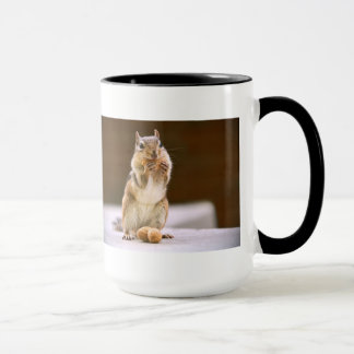 Caneca Chipmunk bonito que come um amendoim
