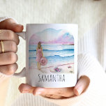 Caneca De Café A vida é melhor na praia personalizada<br><div class="desc">Estas lindas canecas personalizadas de café apresentam uma serena design de aquarela de uma mulher que fica ao lado da costa, segurando um chapéu de praia, com tons suaves de rosa e azul evocando uma cena oceânica serena. As palavras "A vida é melhor na praia" são inscritas elegantemente na tipografia...</div>
