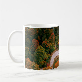 CANECA DE CAFÉ CASA BRANCA E COROA ARREDONDADA POR ÁRVORES