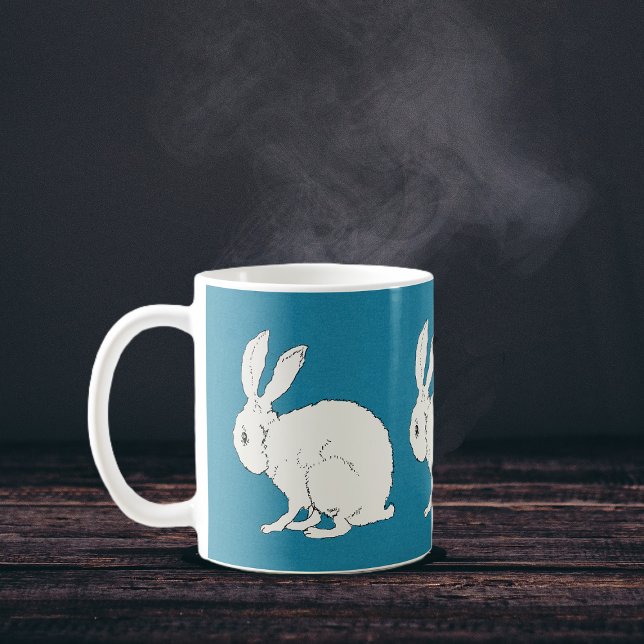 Caneca De Café coelhos brancos elegantes sentados em azul (Simple white sitting rabbits on dark blue circling a coffee or tea mug.)