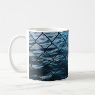 Caneca De Café Corpo de água em frente à cerca de elos de corre