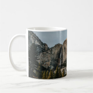 CANECA DE CAFÉ CRUZAMENTO PRÓXIMO DAS ÁRVORES SOB PELE AZUL