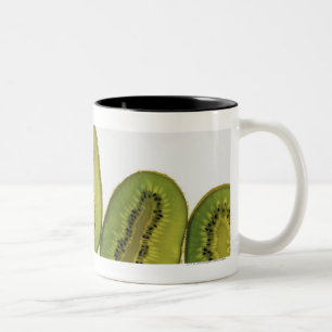 Caneca De Café Em Dois Tons Fim-acima de cinco fatias de fruta de quivi