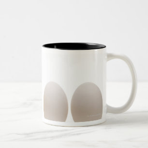 Caneca De Café Em Dois Tons Fim-acima de um pintinho do bebê com três ovos
