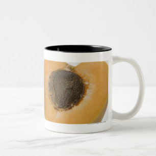 Caneca De Café Em Dois Tons Fim-acima do secção transversal de uma ameixa