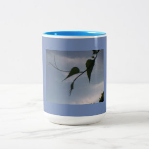 Caneca De Café Em Dois Tons Folha verde no céu azul nebuloso