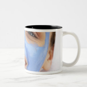 Caneca De Café Em Dois Tons Jovem mulher que veste a máscara facial, sorrindo,