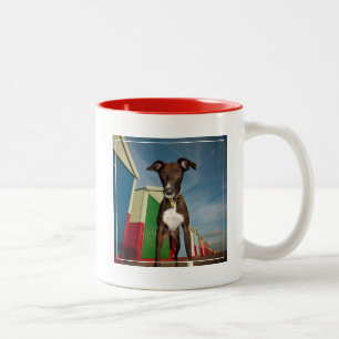 Caneca De Café Em Dois Tons Um Lurcher que está na frente de algumas cabanas
