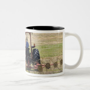 Caneca De Café Em Dois Tons Um menino novo que conduz uma colheita do trator