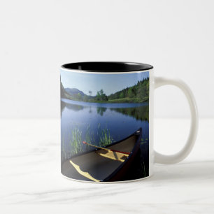 Caneca De Café Em Dois Tons Uma canoa fica na beira de Little Long Pond