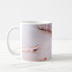 Caneca De Café Pé de pessoa ao lado da pá verde na costa