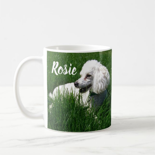 Caneca De Café Uma Poodle Branca Descansada na Grama Verde Lush (Esquerda)
