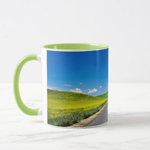 Caneca Estrada rural através de campos de canola de prima