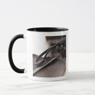 Caneca fim-acima da mão que guardara rédeas do cavalo
