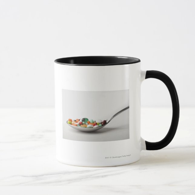 Caneca Fim-acima dos comprimidos em uma colher (Direita)