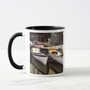 Caneca Nevoeiro cerca quatro barcos atracados.