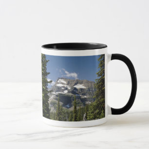 Caneca Pico de montanha entre árvores sob um céu azul