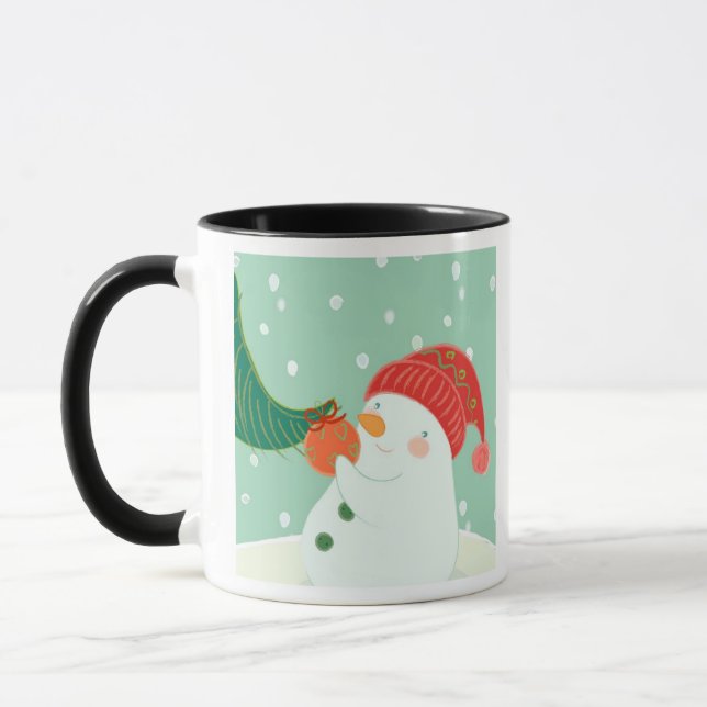 Caneca Um boneco de neve que pendura um ornamento em uma (Esquerda)