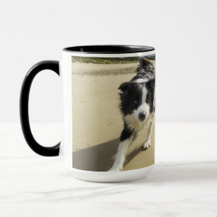 Caneca Um cão de border collie que funciona na praia