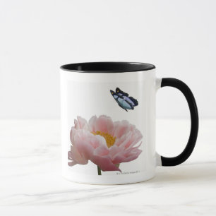 Caneca uma grande peônia cor-de-rosa é visitada por um
