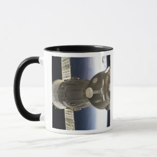 Caneca Uma nave espacial de Soyuz backdropped pela terra