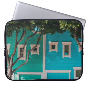 Capa Para Notebook Casas verdes e azuis ao lado de árvores na calça