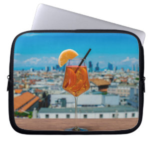 Capa Para Notebook Coquetel Spritz numa mesa com vista a Milão