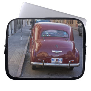 Capa Para Notebook Um carro clássico de Peugeot vermelho estacionado 