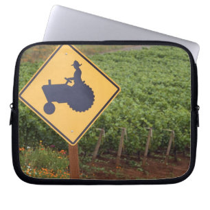 Capa Para Notebook Um sinal de cruzamento de trator amarelo na vinha