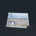 Cartão 18th birthday card with a motor bike<br><div class="desc">A blue motor cycle standing on a beach with fluffy clouds in the sky. Happy Birthday written in rock reflected in the water lying on the sand.</div>