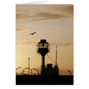 Cartão Barco-farol no por do sol