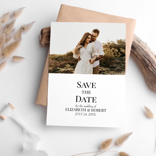 Cartão de Data de Salvamento de Foto Personalizada (Black and White Custom Photo Save the Date Card on a table with neutral boho decor)