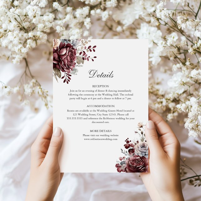 Cartão de Detalhes do Casamento Floral de Sage Gre (Sage Green & Burgundy Floral Wedding Details Card in hands next to tiny white flowers)