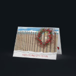 Cartão De Festividades Christmas berry beach wreath on fence<br><div class="desc">berry wreath on beach fence with starfish and sand dollar with water background.
Torn edge border added.</div>