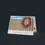 Cartão De Festividades Christmas berry beach wreath on fence<br><div class="desc">berry wreath on beach fence with starfish and sand dollar with water background.
Torn edge border added.</div>