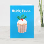 Cartão De Festividades Christmas Card (Welsh) Cupcake with Holly<br><div class="desc">A bright and cheerful Welsh Christmas Card with a sprig of holly on top of an iced cupcake, from a handpainted paper collage by Judy Adamson. The front greeting, in white text on a blue background, is 'Nadolig Llawen!' and the inside message, which you can change, is, '... a Blwyddyn...</div>