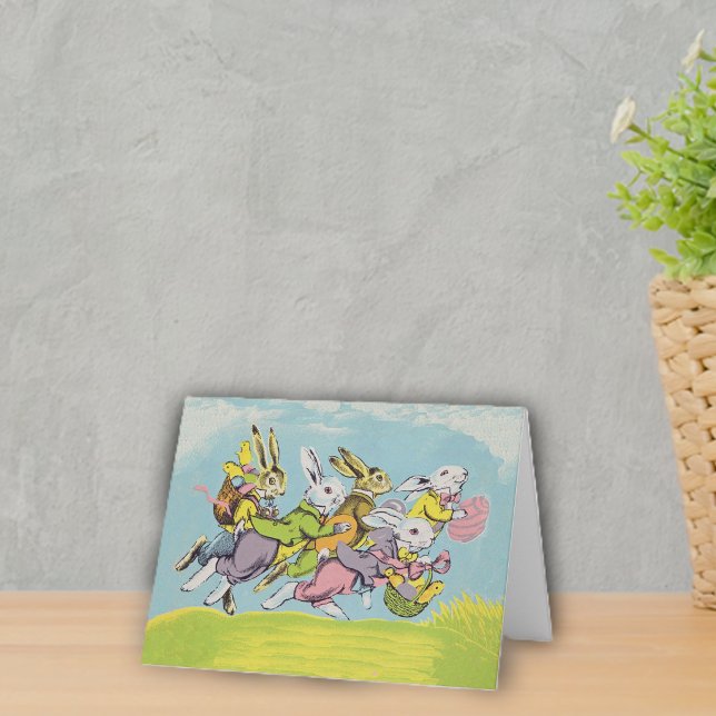 Cartão De Festividades Coelhos da Páscoa Correndo Pastéis (Group running Easter rabbits in pastel clothes eggs baskets in grass under blue sky on notecard.)
