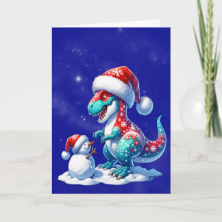 Cartão De Festividades Dinosaur with santa hat building a snowman