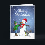 Cartão De Festividades Edifício Snowman<br><div class="desc">O menino construiu um boneco de neve que seu cachorro se sustenta e urina enquanto o menino dá ao boneco de neve um nariz de cenoura.</div>