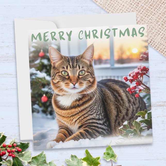 Cartão De Festividades Gato Malhado Na Neve Feliz Natal Elegante (A Christmas card featuring a cute tabby cat in the snow, with ivy, Christmas tree and red berries
)