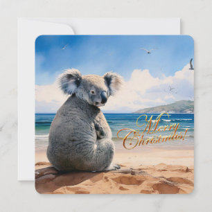 Cartão De Festividades Koala em uma praia arenosa Feliz Natal