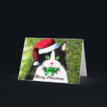 Cartão De Festividades Merry Christmas Tuxedo Cat in Santa Hat<br><div class="desc">Black and white tuxedo cat in front of the tree,  wishing a merry Christmas. Customizable text.</div>