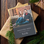 Cartão De Festividades Natal moderno | Foto mínima do Casal<br><div class="desc">Na moda, foto de feriado moderno dobrou o cartão com fotos com uma tipografia clássica, que diz "desejos de feriado quentes - da nossa família à sua", em conjunto com uma letra manuscrita para o seu nome de família, em branco, num fundo preto azulado. A saudação e o nome podem...</div>
