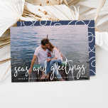 Cartão De Festividades Seas and Greetings | Nautical Holiday Photo Card<br><div class="desc">Send holiday greetings to friends and family in nautical style with these coastal chic holiday photo cards. Design features your favorite photo with "seas and greetings" overlaid in white hand sketched lettering. Personalize with your names, custom greeting (shown with "Merry Christmas") and the year. Cards reverse to a white nautical...</div>