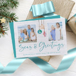 Cartão De Festividades Seas e Saudações Feriado do Ornamento de Seashell<br><div class="desc">Seas e Saudações Seashell Ornament Holiday Foto Cartões de Natal com azul-turquesa e ornamentos de conchas arenosas pendurados na velejação da juta com tipografia elegante. Adicione duas das suas fotos e uma mensagem pessoal para um cartão náutico divertido. Entre em contato conosco em cedarandstring@gmail.com se precisar de assistência com o...</div>