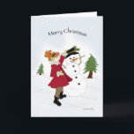 Cartão De Festividades Snowman e Little Girl<br><div class="desc">Menina num casaco vermelho vestindo um boneco de neve na neve</div>